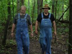 Digger and Mark walking through the woods to their hidden still sites. 