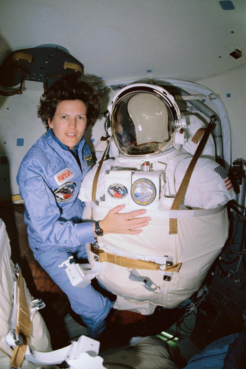 (April 25, 1990) STS-31 Mission Specialist Kathryn D. Sullivan poses for a picture before donning her space suit and extravehicular mobility unit in the airlock of Discovery. Onboard the April 25, 1990 shuttle mission that deployed the Hubble Space Telescope, Sullivan remained ready to do a spacewalk in case there were problems putting the orbital observatory into space. The deployment went smoothly, and no spacewalk was necessary.  Image # : s31-11-033