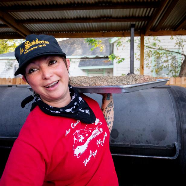Alison Clem smiles as she holds up a tray of brisket ready for the smoker at la Barbecue in Austin, Texas. Chef LeAnn Mueller with the help of her wife Alison run la Barbecue with recipes and flavors inspired by their travels around the world.