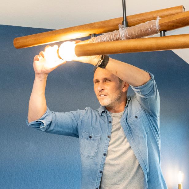 Photographer Ian Shive screws a lightbulb into a new lighting fixture as part of a home office renovation in Pflugerville, Texas.