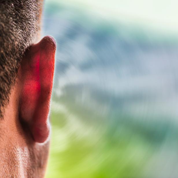 Close up of ear of Caucasian man and sound waves