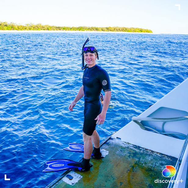 Robert Irwin smiling in snorkel gear, standing at the stern of Croc One before snorkeling at Lady Elliot Island, Australia