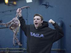 Captain Jake Anderson enthusiastically shows off a big King Crab aboard the Saga.