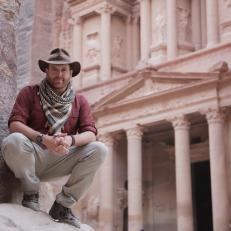 Josh Gates amidst ruins in Petra, Jordan.