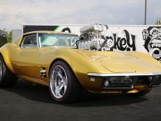 A shimmering side view of the 1968 Gold Corvette atop a GMG platform.