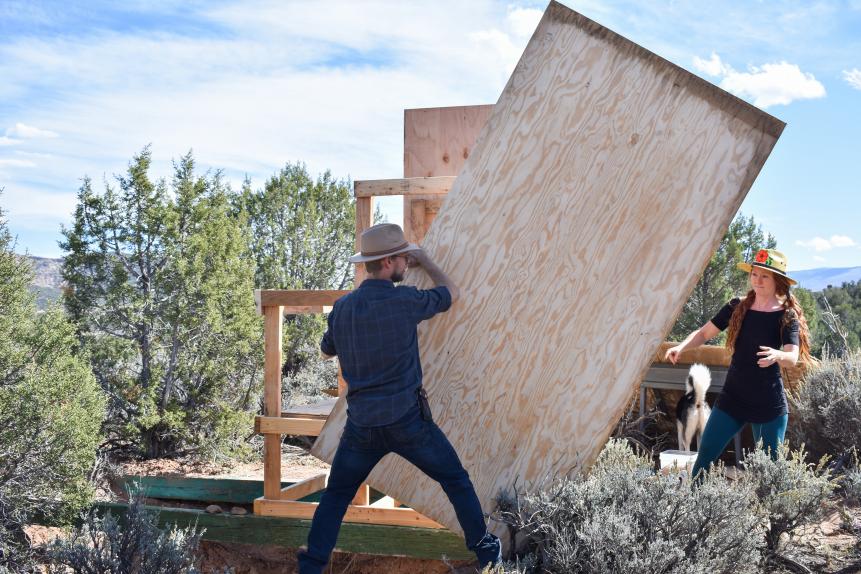 Spencer Lenz and Lyndsay Mckeever move some plywood to build an outhouse in De Beque, CO.