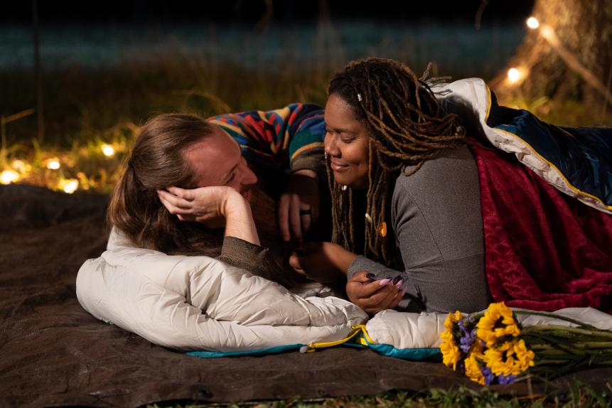Joe Watts laughs while lying down on a blanket with Myesha Price after their wedding ceremony in Centre, AL.