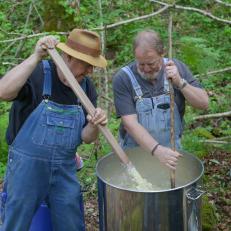 Mark and Digger stir their barrel of mash.