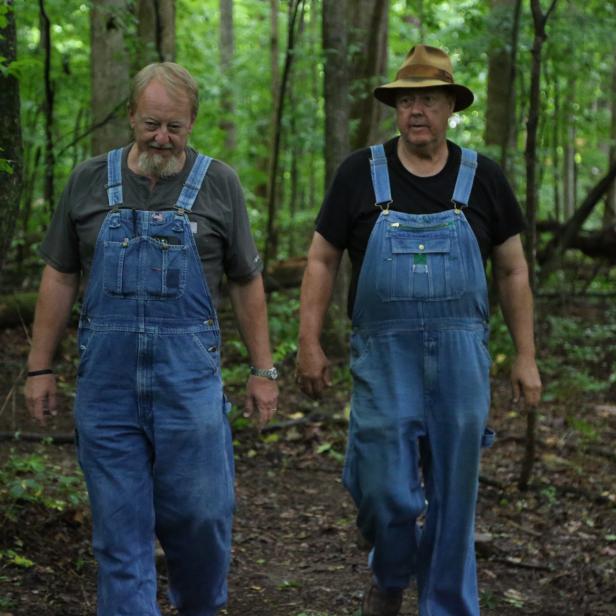Digger and Mark walking through the woods to their hidden still sites. 