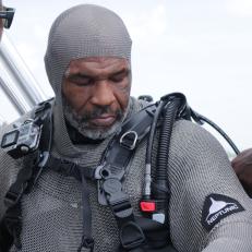 Mike Tyson suited up in sharkproof chainmail gets assistance with his equipment