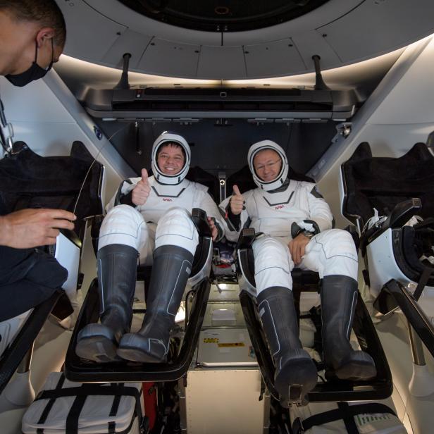 NASA astronauts Robert Behnken, left, and Douglas Hurley are seen inside the SpaceX Crew Dragon Endeavour spacecraft onboard the SpaceX GO Navigator recovery ship shortly after having landed in the Gulf of Mexico off the coast of Pensacola, Florida, Sunday, Aug. 2, 2020. The Demo-2 test flight for NASA's Commercial Crew Program was the first to deliver astronauts to the International Space Station and return them safely to Earth onboard a commercially built and operated spacecraft. Behnken and Hurley returned after spending 64 days in space. Photo Credit: (NASA/Bill Ingalls)