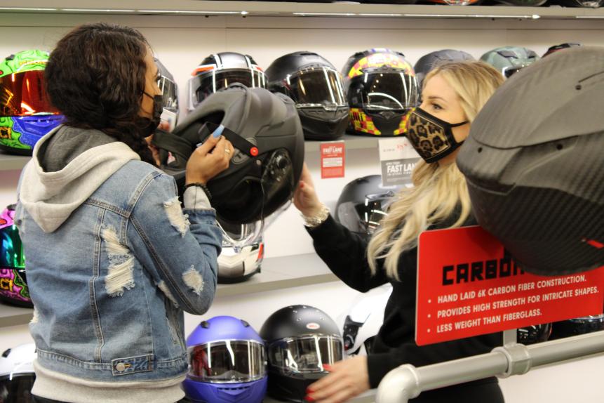 Lizzy Musi helps Armani Johnson try on a helmet.