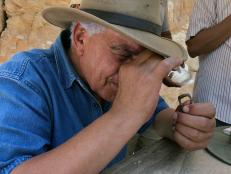 Zahi Hawass inspect the inscription on a bronze ring unearthed during the excavation in the West Valley of the Kings