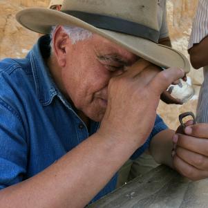 Zahi Hawass inspect the inscription on a bronze ring unearthed during the excavation in the West Valley of the Kings