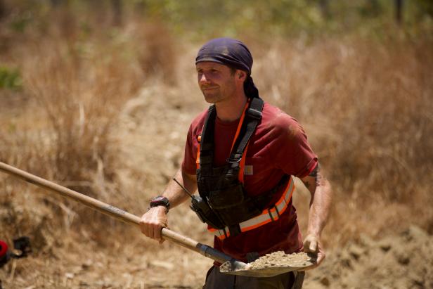 Danny Etheridge holding a shovel of dirt.