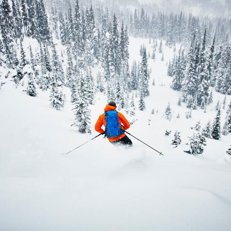Man skiing though fresh snow while on backcountry ski tour