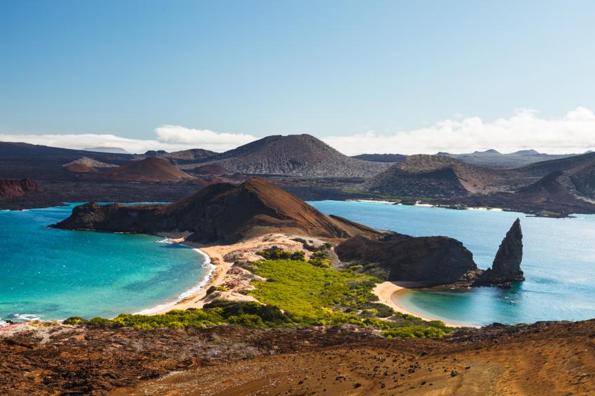 View on the volcanic landscape of Bartolome Island with famous Pinnacle Rock and Golden Beach, Galapagos Islands, Ecuador