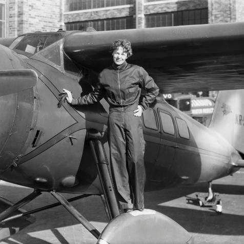 (Original Caption) Amelia Earhart (1898-1937), American aviatrix, first woman to cross Atlantic. Photograph showing her with airplane.