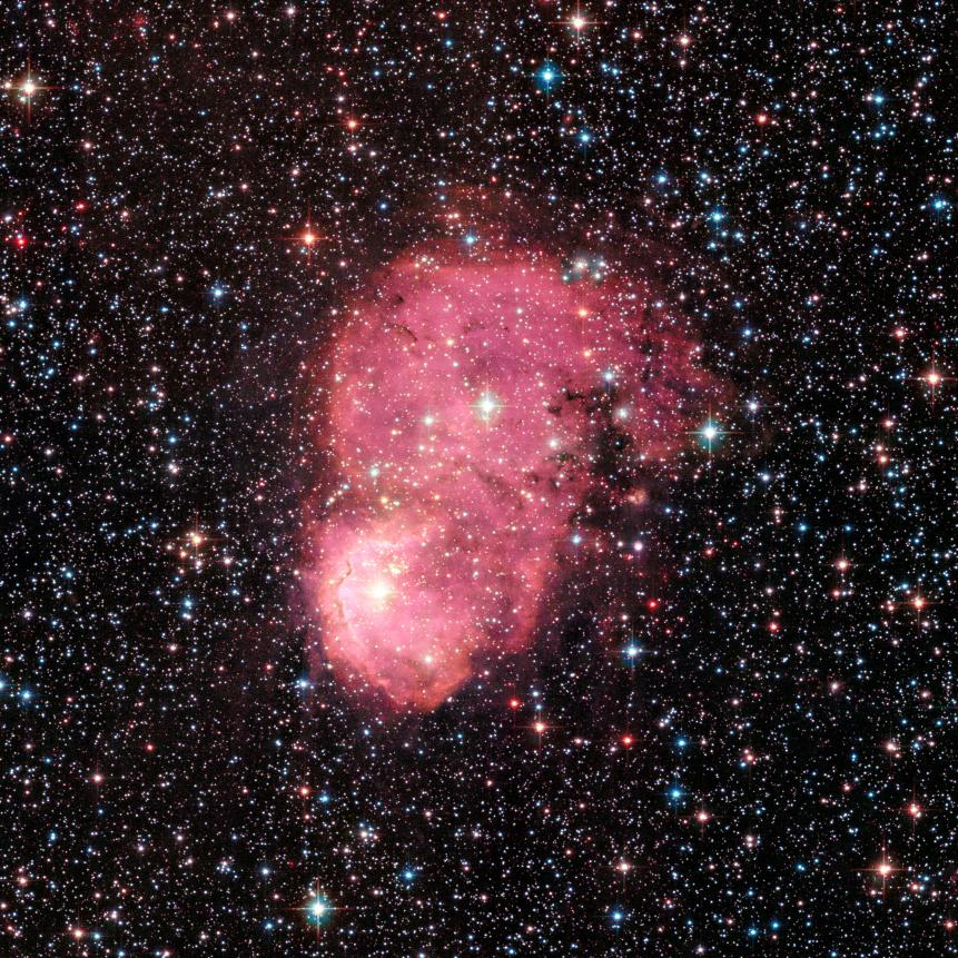 NASA's Hubble Space Telescope captured two festive-looking nebulas, situated so as to appear as one. They reside in the Small Magellanic Cloud, a dwarf galaxy that is a satellite of our Milky Way galaxy. Intense radiation from the brilliant central stars is heating hydrogen in each of the nebulas, causing them to glow red.

The nebulas, together, are called NGC 248. They were discovered in 1834 by the astronomer Sir John Herschel. NGC 248 is about 60 light-years long and 20 light-years wide. It is among a number of glowing hydrogen nebulas in the dwarf satellite galaxy, which is located approximately 200,000 light-years away in the southern constellation Tucana.  June 2017