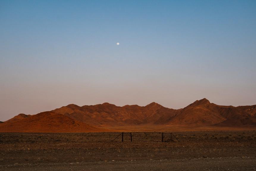 mesmeringing evening moon at NamibRand Naturreservat with mountains and desert sand and the moon in Namibia, Africa