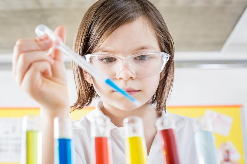 Girl(10-11) in school laboratory conducting a scientific experiment colored liquids in test tubes using a pipette, School Science Project,Ideas,Imagination,Laboratory Coat,chemistry, Discovery,Education,Enjoyment,test tubes, science project, Pipette,Chemistry,Confidence