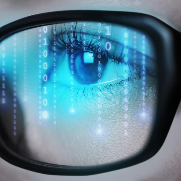 Binary numbers code of computer monitor reflect to her eyeglasses.