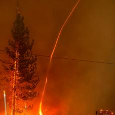 A fire whirl shoots into the sky as flames from the Hog fire jump highway 36 about 5 miles from Susanville, California on July 20, 2020. - The fire exploded to more than 6,000 acres and created its own weather, generating lightning, thunder, rain and fire whirls out of a huge pyrocumulonimbus ash plume towering above. The 
Lassen County Sheriff's office issued a mandatory evacuation order for the area. (Photo by JOSH EDELSON / AFP) (Photo by JOSH EDELSON/AFP via Getty Images)