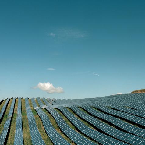 Solar panels field on hillside, sunny weather