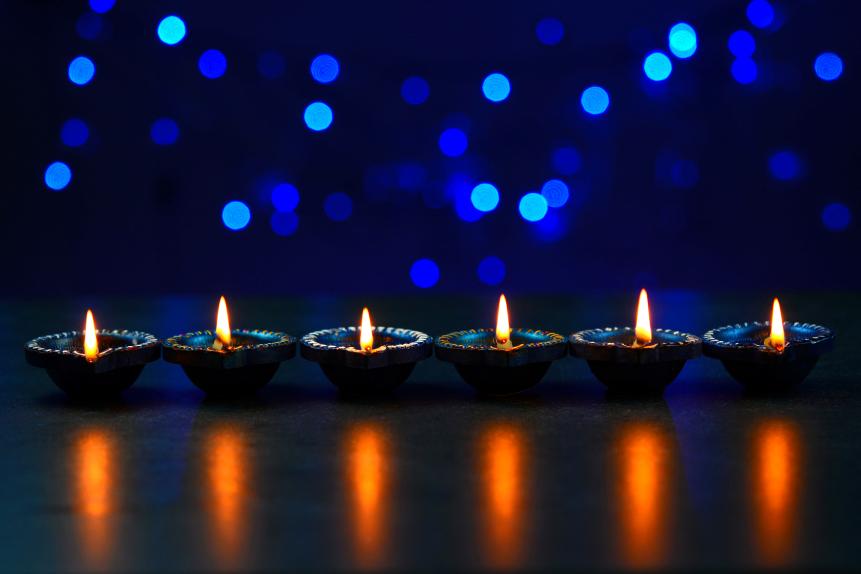 Decorated Diwali lights with colorful diya oil lamp with blue bokeh background.