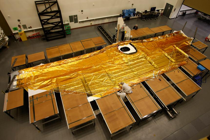 Bruce Blackman, mechanical technician, left, and Kathryn Friend, sun shield integration and test manager, work on folding membranes of a full scale test article five-layer sun shield, made of uncoated kapton, that will shield the James Webb Space Telescope from the sun and heat. The sun shield is being built by Northrop Grumman Corp. in Redondo Beach.  (Photo by Allen J. Schaben/Los Angeles Times via Getty Images)