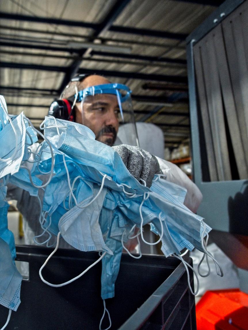 A worker at the start-up Plaxtil company handles protective masks as they are made ready for recycling into plastic to make visors, door openers, mask fasteners, on August 25, 2020 in Chatellerault, western France. - The use of disposable masks has become an environmental issue with people around the world using and throwing away millions of masks worn to curb the spread of the novel coronavirus, COVID-19. (Photo by GUILLAUME SOUVANT / AFP) (Photo by GUILLAUME SOUVANT/AFP via Getty Images)