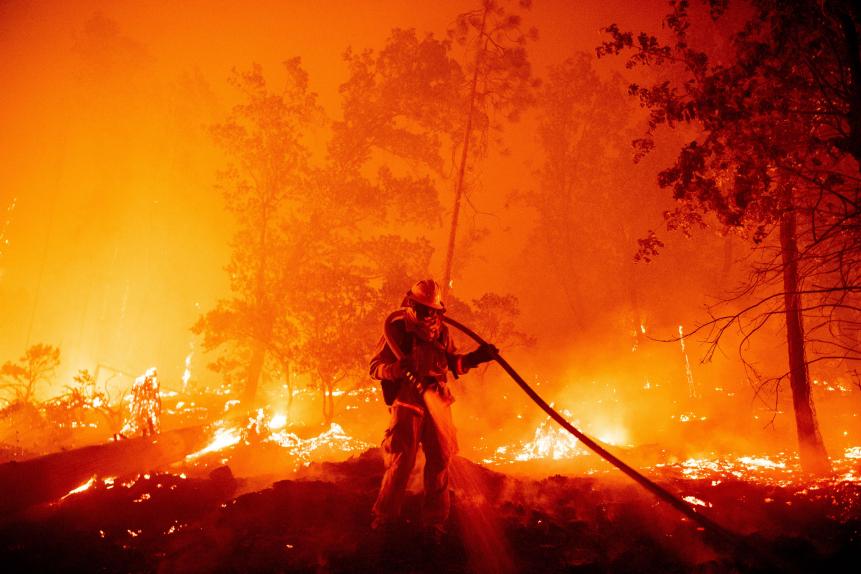 TOPSHOT - A firefighter douses flames as they push towards homes during the Creek fire in the Cascadel Woods area of unincorporated Madera County, California on September 7, 2020. - A firework at a gender reveal party triggered a wildfire in southern California that has destroyed 7,000 acres (2,800 hectares) and forced many residents to flee their homes, the fire department said Sunday. More than 500 firefighters and four helicopters were battling the El Dorado blaze east of San Bernardino, which started Saturday morning, California Department of Forestry and Fire Protection (Cal Fire) said. (Photo by JOSH EDELSON / AFP) (Photo by JOSH EDELSON/AFP via Getty Images)