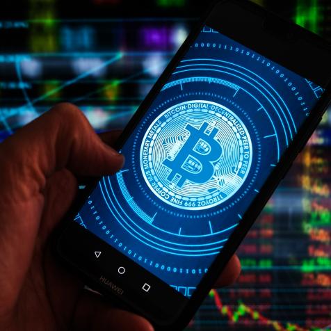 POLAND - 2021/04/26: In this photo illustration a Bitcoin logo seen displayed on a smartphone with stock market percentages in the background. (Photo Illustration by Omar Marques/SOPA Images/LightRocket via Getty Images)