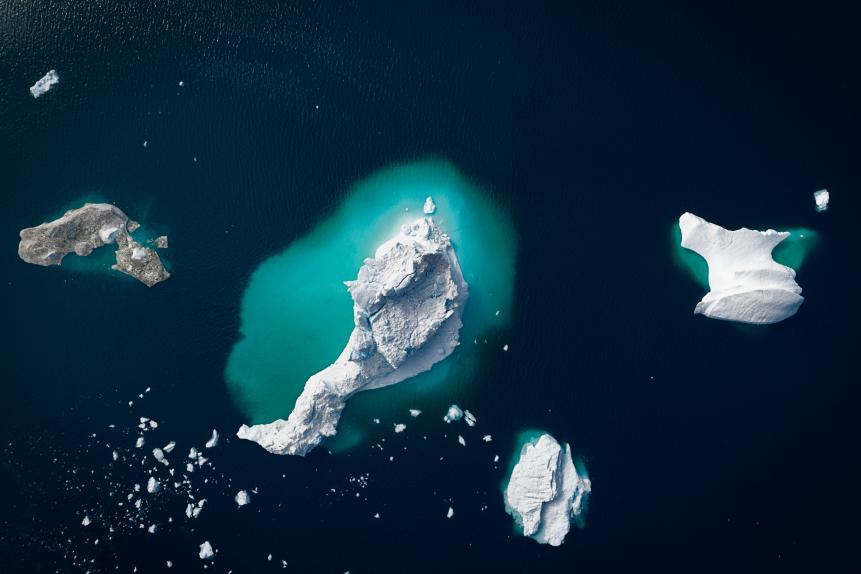 Huge icebergs floating in the Arctic ocean, in Ilulissat, Greenland, Unesco World Heritage, the arctic water is dark, and the icebergs stand out into the ocean, the picture has been taken with a drone