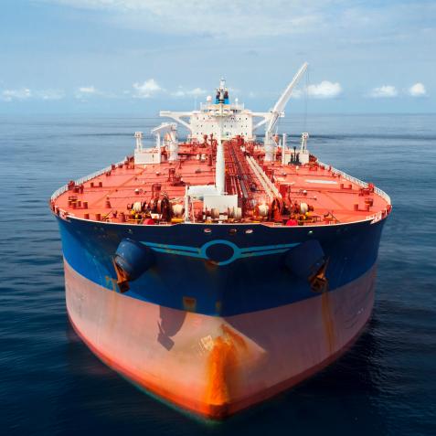 Aerial photo of a large oil tanker floating in calm seas.