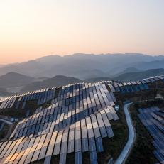 Aerial view of the solar power plant on the top of the mountain at sunset