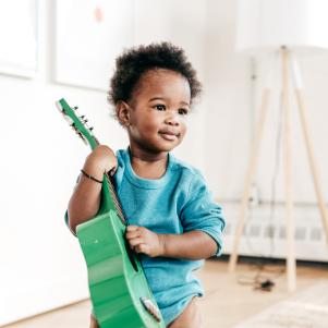Toddler holding guitar