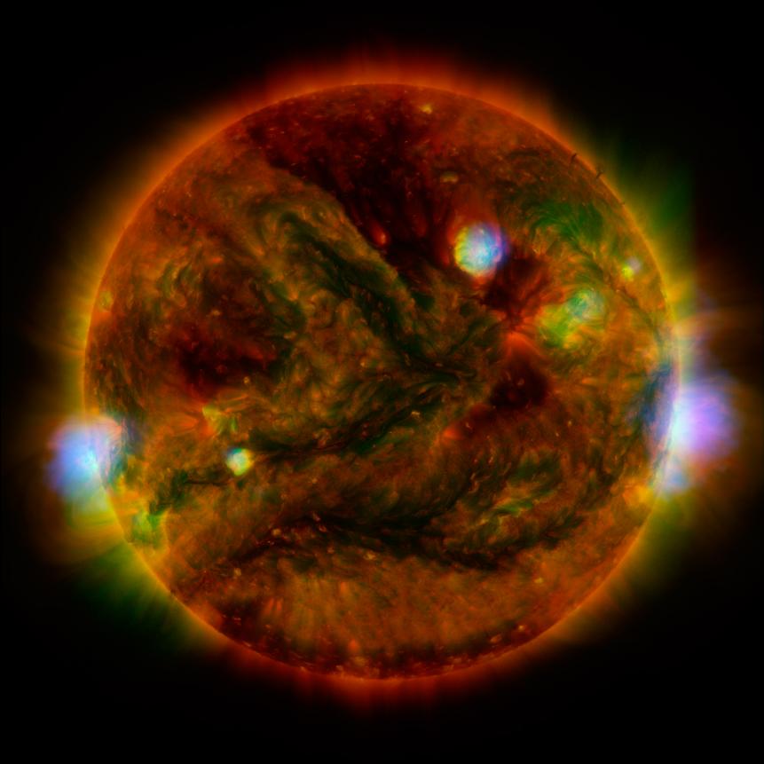 Flaring, active regions of our Sun are highlighted in this image combining observations from  Nuclear Spectroscopic Telescope Array, or NuSTAR (shown in blue); low-energy X-rays from Japan's Hinode spacecraft are green; and extreme ultraviolet light from Solar Dynamics Observatory, or SDO, are yellow and red. This NuSTAR image is a mosaic made from combining smaller images.  The active regions across the Sun’s surface contain material heated to several millions of degrees. The blue-white areas showing the NuSTAR data pinpoint the most energetic spots. During the observations, microflares went off, which are smaller versions of the larger flares that also erupt from the sun's surface. The microflares rapidly release energy and heat the material in the active regions.