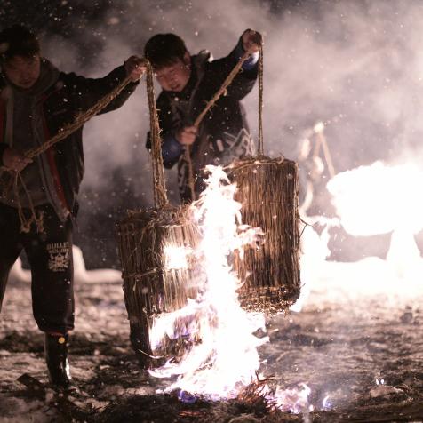 Participants burns the straw for the fire ring performance during the Hiburi Kamakura Festival in Kakunodate town, Semboku, Akita Prefecture, Japan on Feb. 14, 2019. The 400 year old ritual takes place annually on Lunar New Year season to drive away evil spirits from a rice field, to wish for prosperity, avoidance of diseases and also for family safety. Hiburi Kamakura is a traditional New Years event in which participants light a tenpitsu, a bundle of rice ears and swing around their body and creates the fire rings that illuminates the snow-covered park where the event is held.  (Photo by Richard Atrero de Guzman/NurPhoto via Getty Images)
