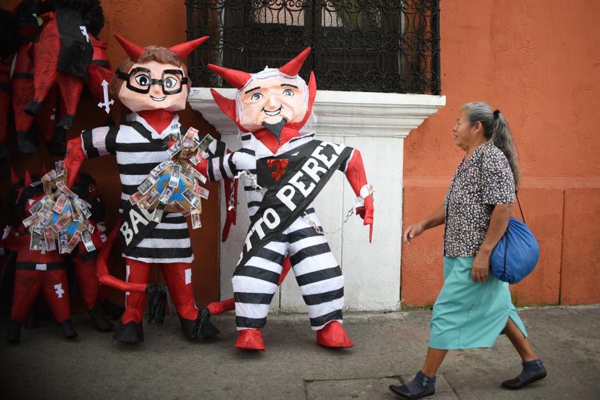 Two dolls depicting former President Otto Perez Molina (R) and ex-vice president Roxana Baldetti are displayed for sale in Guatemala City on December 3, 2015. The dolls were built to be fired during the next December 7 "Quema del Diablo" festivity. Perez and Baldetti  are accused of receiving bribes and are on remand. / AFP / JOHAN ORDONEZ        (Photo credit should read JOHAN ORDONEZ/AFP via Getty Images)