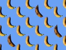 Banana with condom on blue background.