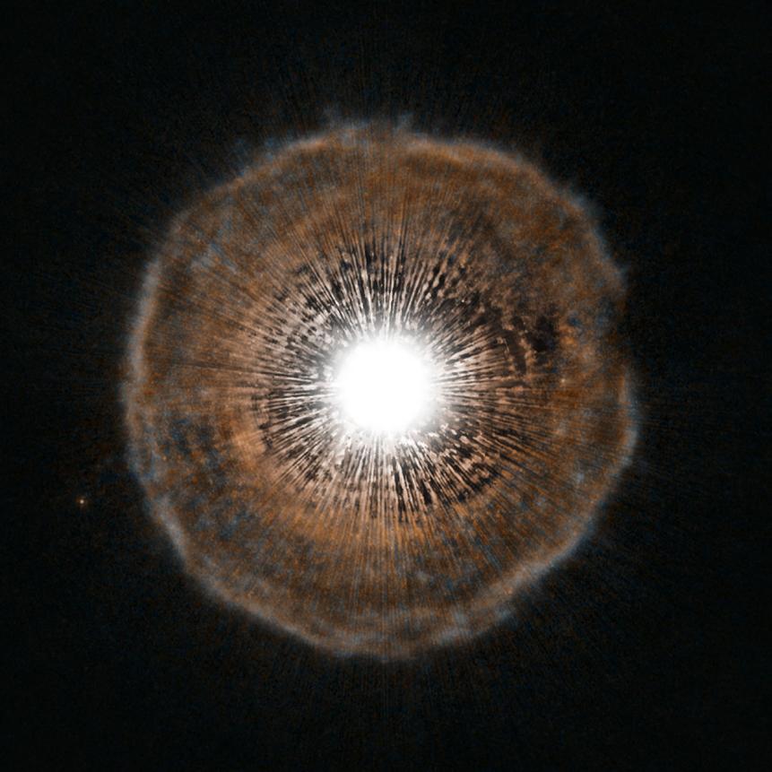 A bright star is surrounded by a tenuous shell of gas in this unusual image from the NASA/ESA Hubble Space Telescope. U Camelopardalis, or U Cam for short, is a star nearing the end of its life. As it begins to run low on fuel, it is becoming unstable. Every few thousand years, it coughs out a nearly spherical shell of gas as a layer of helium around its core begins to fuse. The gas ejected in the star’s latest eruption is clearly visible in this picture as a faint bubble of gas surrounding the star. U Cam is an example of a carbon star. This is a rare type of star whose atmosphere contains more carbon than oxygen. Due to its low surface gravity, typically as much as half of the total mass of a carbon star may be lost by way of powerful stellar winds. Located in the constellation of Camelopardalis (The Giraffe), near the North Celestial Pole, U Cam itself is actually much smaller than it appears in Hubble’s picture. In fact, the star would easily fit within a single pixel at the centre of the image. Its brightness, however, is enough to overwhelm the capability of Hubble’s Advanced Camera for Surveys making the star look much bigger than it really is. The shell of gas, which is both much larger and much fainter than its parent star, is visible in intricate detail in Hubble’s portrait. While phenomena that occur at the ends of stars’ lives are often quite irregular and unstable (see for example Hubble’s images of Eta Carinae, potw1208a), the shell of gas expelled from U Cam is almost perfectly spherical. The image was produced with the High Resolution Channel of the Advanced Camera for Surveys.