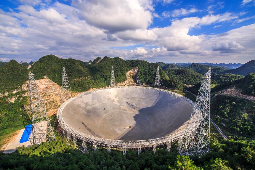 The Five-hundred-meter Aperture Spherical Telescope (FAST) is nestled within a natural basin in China's remote and mountainous southwestern Guizhou province. Nicknamed Tianyan, or the Eye of Heaven, the new radio telescope is seen in this photograph taken near the start of its testing phase of operations on September 25, 2016. Designed with an active surface for pointing and focusing, its enormous dish antenna is constructed with 4,450 individual triangular-shaped panels. The 500 meter physical diameter of the dish makes FAST the largest filled, single dish radio telescope on planet Earth. FAST will explore the Universe at radio frequencies, detecting emission from hydrogen gas in the Milky Way and distant galaxies, finding faint galactic and extragalactic pulsars, and searching for potential radio signals from extraterrestrials.