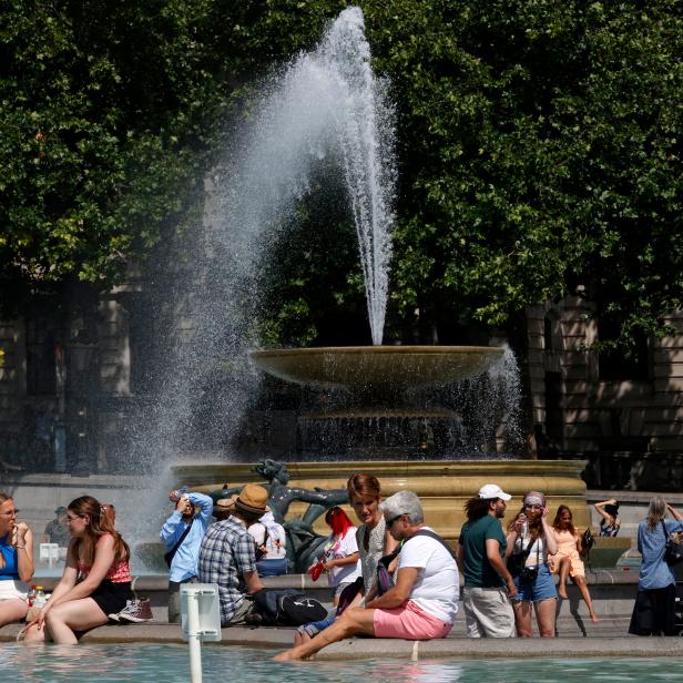 People cool off beside the fountains in Trafalgar Square in central London on June 17, 2022, on what is expected to be the hottest day of the year so far in the capital. - A Level 3 Heat-Health alert for London, the East of England and the South East has been announced to help protect health services, the UK Health Security Agency (UKHSA) has said, Friday. (Photo by CARLOS JASSO / AFP) (Photo by CARLOS JASSO/AFP via Getty Images)