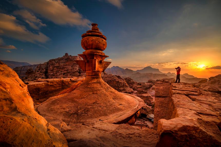 Photographer Standing on Top of Petra Monastery at Sunset, Petra, Jordan, in the ancient nabbatean city of Petra in Jordan at sunset with a view to the city of Wadi Musa.