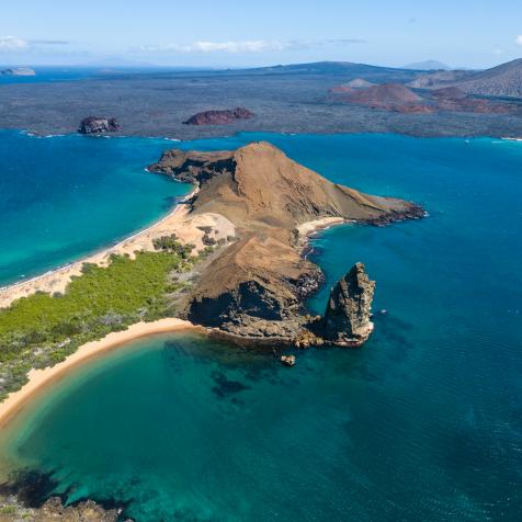 Aerial view of the famous Pinnacle Rock on the small island of Bartolome, Galapagos, Ecuador. In the background is Santiago island.